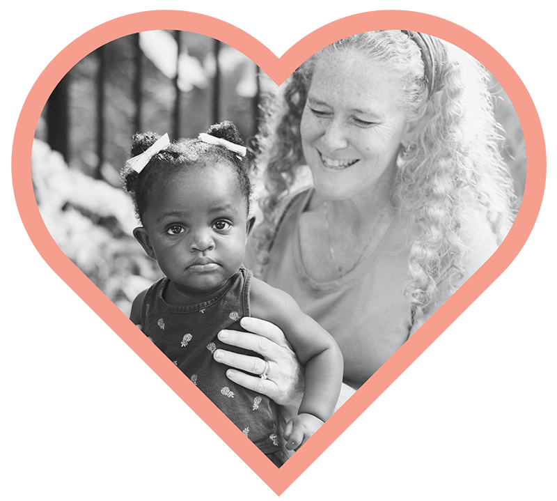 Caucasian Woman smiling holding an African American child